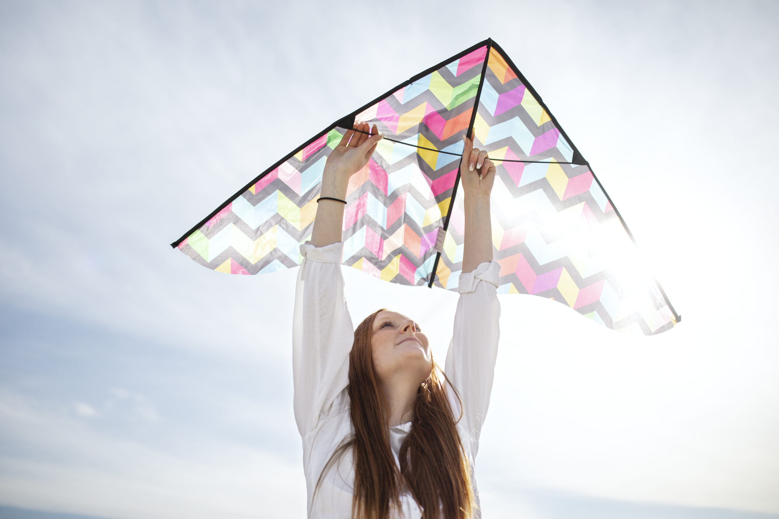 Young adult flying a kite as a symbol of freedom within structure